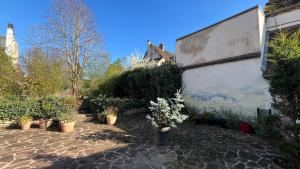 a courtyard with potted plants and a building at Le Chanoine - Centre Ville - Sens in Sens