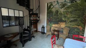a living room with a spiral staircase and a mural at Le Chanoine - Centre Ville - Sens in Sens