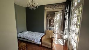 a bedroom with a bed and a chair and a window at Le Chanoine - Centre Ville - Sens in Sens