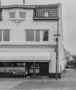 a black and white photo of a building with a street light at De boekanier in Meerssen