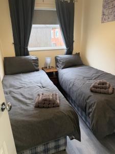 a bedroom with two beds and a window at 2 Broadside Chalet Park in Stalham +5 photos