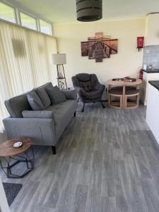 a living room with a couch and a table at 2 Broadside Chalet Park in Stalham
