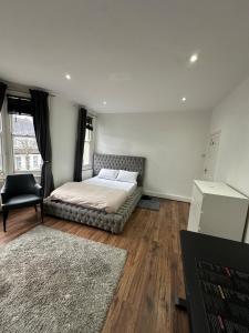 a bedroom with a bed and a desk and a chair at Massive cozy room with shared bathroom in Thornton Heath
