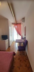 a living room with a table and a purple chair at Guest House AB Adria Home in Rovinj