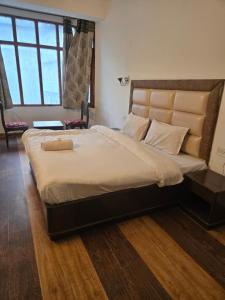 a large bed in a bedroom with a large window at Kalinga Intercontinental By Maa Vaishno Hotels India Pvt Ltd in Manāli