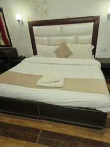 a bedroom with a large bed with white sheets and pillows at Kalinga Intercontinental By Maa Vaishno Hotels India Pvt Ltd in Manāli