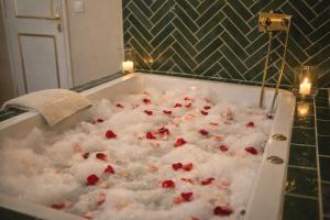 a bath tub filled with red roses in a bathroom at Château de la Tourlandry in Chemillé +26 photos