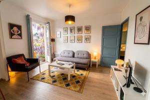 a living room with a couch and a tv at Les Capucines, comme chez soi, loin de chez soi in Aubenas