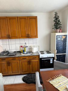 a kitchen with wooden cabinets and a stove top oven at Sweet home Jagodina in Jagodina