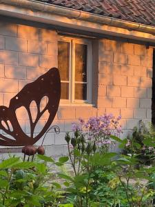 a butterfly statue in front of a house at Le Moulin d'Audenfort in Clerques