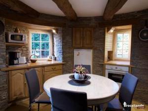 a kitchen with a table and chairs in a room at Le Moulin de Bréhaut in Augan