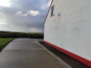 a white building with a window on the side of it at Gerry's house in Milltown Malbay