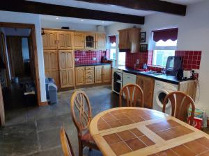 a kitchen with a wooden table and chairs in it at Gerry's house in Milltown Malbay