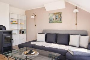 a living room with a couch and a glass table at Vierseitenhof Hasenfelde - Ferienwohnung Feldblick in Steinhöfel