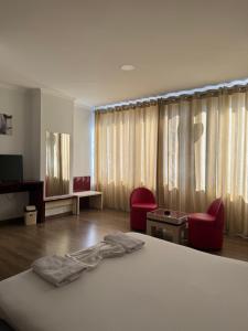 a bedroom with a bed and two red chairs at Ikea hotel in Kashari