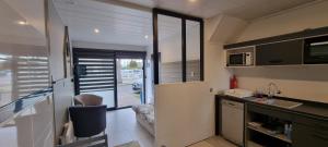 a small kitchen with a sink and a microwave at Aux Passagers de la Baie 2 Maison 3 Etoiles 2 couchages Terrasse Proche Mer Crotoy in Le Crotoy