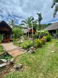 a house with a wooden walkway in front of a yard at Tamarin Lodge in Ampangorinana