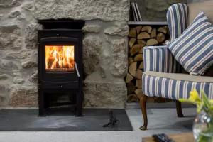 a fireplace in a living room with a stove at Sunny Corner in Mousehole +7 photos