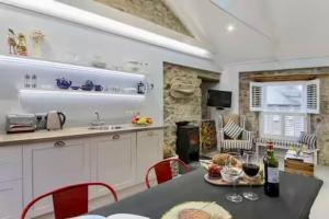 a kitchen with a table with wine glasses on it at Sunny Corner in Mousehole