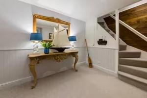 a room with a table with a mirror and stairs at Sunny Corner in Mousehole