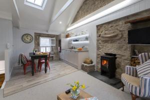 a living room with a table and a stone fireplace at Sunny Corner in Mousehole