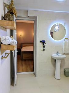 a bathroom with a sink and a mirror and a bed at Tomas Guesthouse in Lagodekhi +36 photos