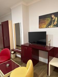 a living room with a tv and a red desk at Ikea hotel in Kashari +45 photos