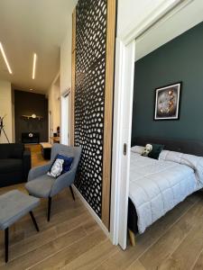 a bedroom with a bed and a chair in a room at APART_SANVICENTE 6 in Vigo