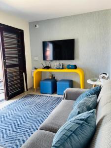 a living room with a couch and a flat screen tv at Labonita House - Pilar in Itamaracá