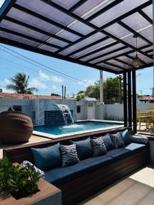 a patio with a blue couch and a swimming pool at Labonita House - Pilar in Itamaracá