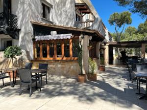 a patio with tables and chairs and a building at Don Carlos in Paguera