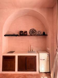 a kitchen with a sink and a refrigerator in a room at Le Bohémien Suites Cabana in Dalung