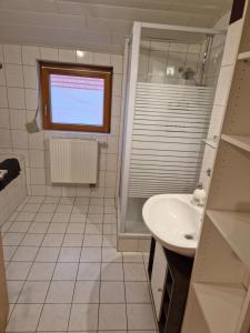 a white bathroom with a sink and a window at Herzstück in Grafenrheinfeld