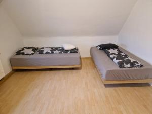 two beds in a room with wooden floors at Herzstück in Grafenrheinfeld