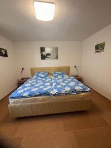 a bedroom with a bed with a blue comforter at Ferienwohnung Haus Veronika in Wegscheid