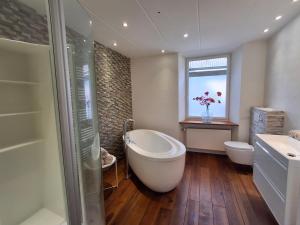 a bathroom with a tub and a toilet and a sink at B&B Haus Valmosa in Valwig +56 photos