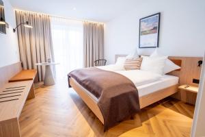 ein Schlafzimmer mit einem Bett und einem großen Fenster in der Unterkunft Das Exter - modernes Self Check-in Hotel am Chiemsee in Übersee