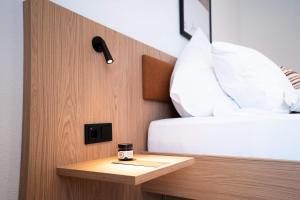 ein Bett mit einer Kaffeetasse auf einem Tisch neben einem Bett in der Unterkunft Das Exter - modernes Self Check-in Hotel am Chiemsee in Übersee