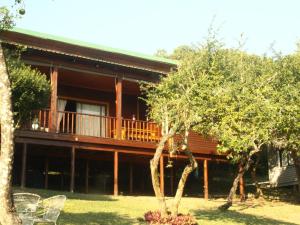 a large house with a balcony and trees at Nhucha Villas in Santa Maria