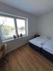 a bedroom with two beds and a window at Apartamenty Tarcal in Tarcal