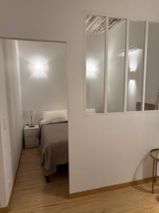 a white room with a bed and a mirror at Très Grand studio neuf 50 m du port Lovely charrons 2 in Saint-Tropez