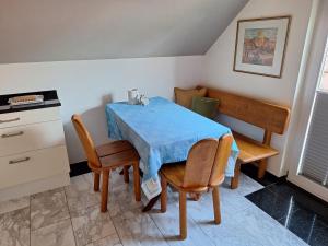 ein Esszimmer mit einem blauen Tisch und Stühlen in der Unterkunft Eselblick in Steinwenden