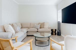 a living room with a white couch and a table at Salt & Feather in Yzerfontein