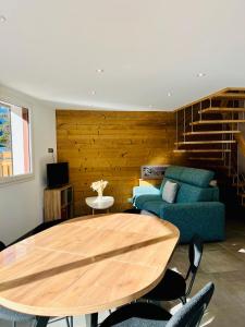 a living room with a table and a couch at Chalet Douce Noire in Brides-les-Bains