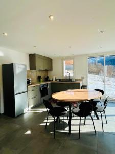 a kitchen with a table and chairs and a refrigerator at Chalet Douce Noire in Brides-les-Bains
