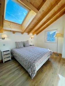 a bedroom with a bed and a large window at Chalet Douce Noire in Brides-les-Bains