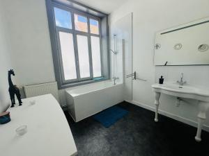 a bathroom with a sink and a tub and a sink and a toilet at Logement Océan in Boulogne-sur-Mer