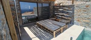 a balcony with two benches and a view of the ocean at Piperi Suites in Kithnos