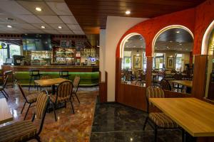 a restaurant with tables and chairs and a bar at Hotel Britania San Borja in Lima