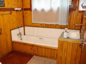 a bathroom with a bath tub and a sink at Nhucha Villas in Santa Maria